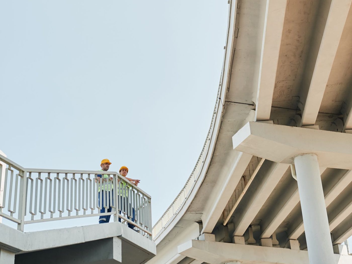 Two engineers inspecting a concrete overpass